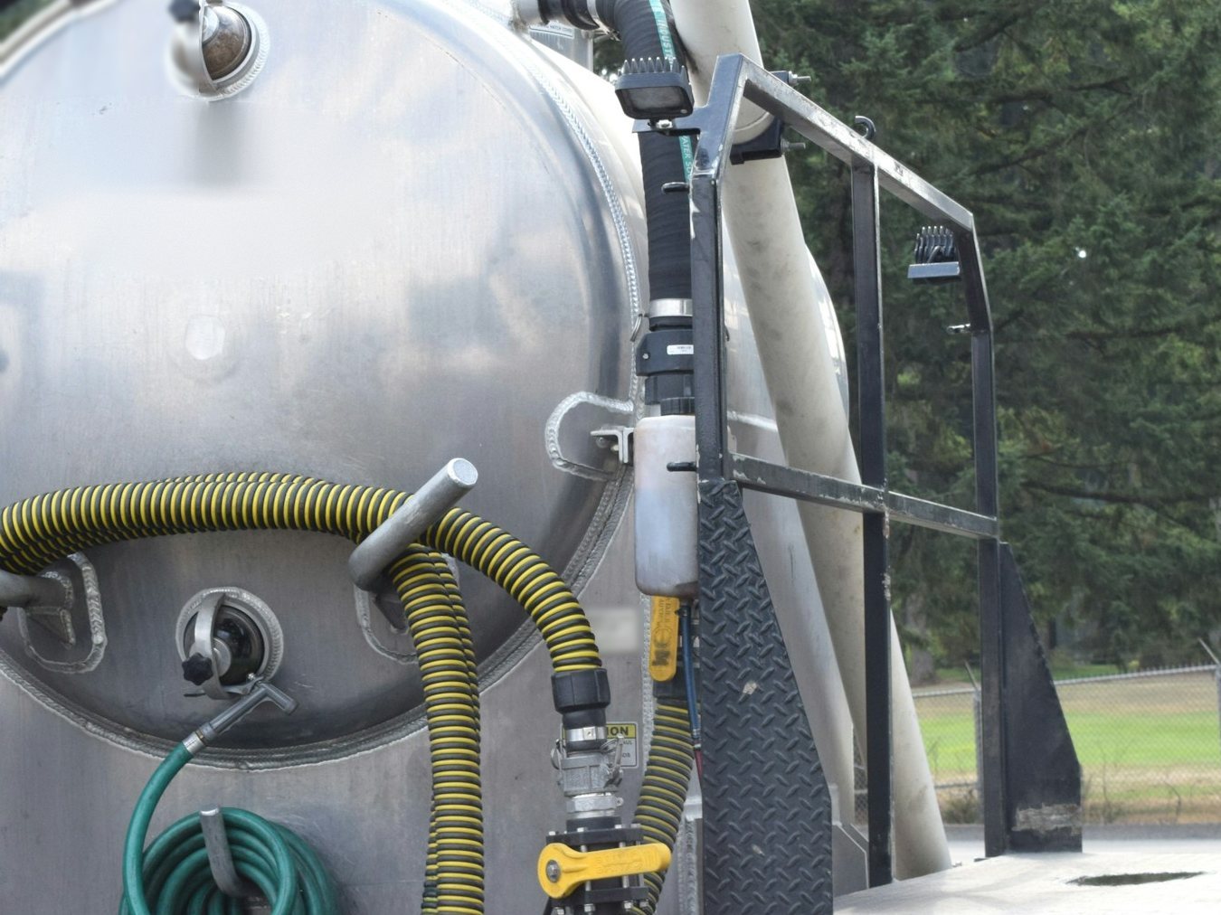 Steel tank, valves and coiled suction hose on a septic vacuum pump truck